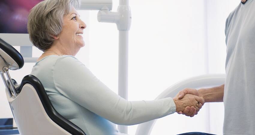 Old Woman Patient Shaking Hands with Dentist 1