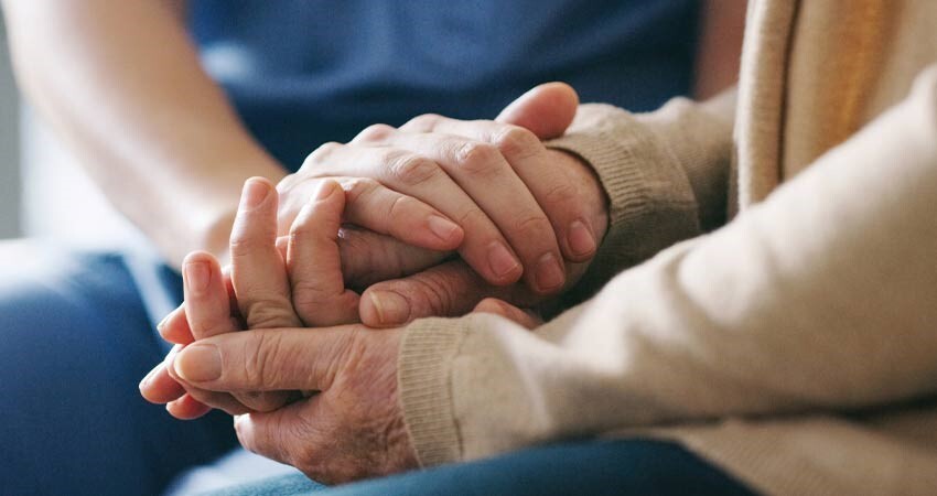 Dental team member holds patient's hand